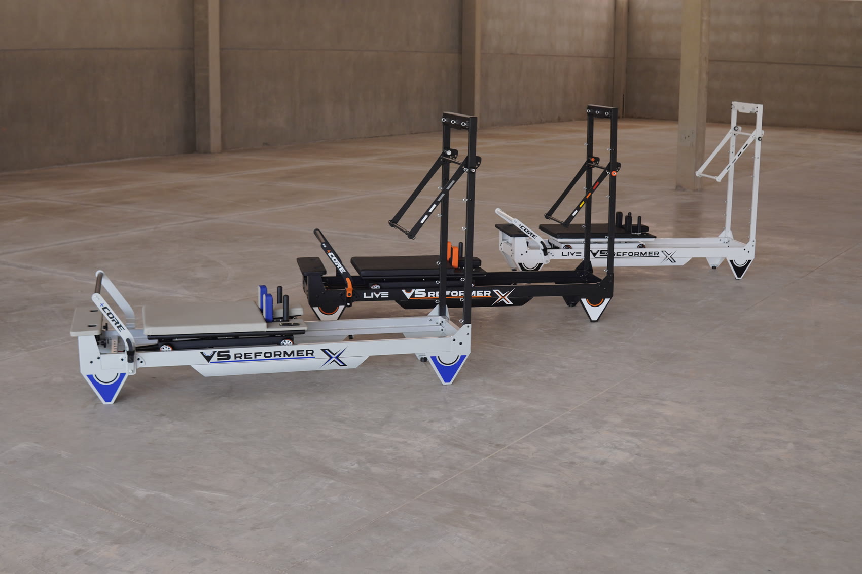 Live Pilates reformers in multiple colors in a studio setting